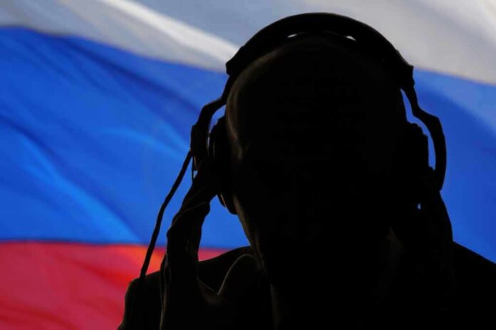 shutterstock_1390174292 silhouetted person wearing headphones before a tricolor flag
