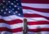 Final Showdown, High Stakes: Michigan On Edge Microphone in front of an American flag backdrop