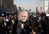 Qasem Soleimani portrait held aloft in a crowded street gathering