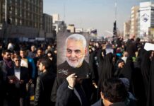Qasem Soleimani portrait held aloft in a crowded street gathering