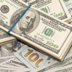 Stack of US hundred-dollar bills bound with a blue band