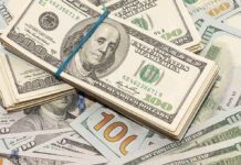 Stack of US hundred-dollar bills bound with a blue band