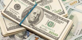 Stack of US hundred-dollar bills bound with a blue band