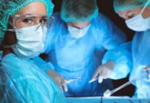 Double Amputee After Unthinkable OR Blunder surgeon in protective gear looking at camera during operation