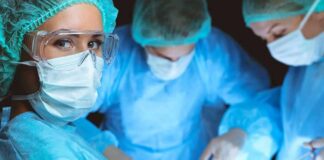 surgeon in protective gear looking at camera during operation