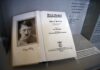 Open historical book on display with portrait and title page