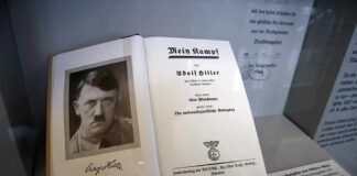 Open historical book on display with portrait and title page