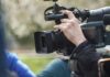 videographer operating a professional camcorder outdoors