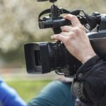 videographer operating a professional camcorder outdoors