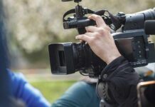 videographer operating a professional camcorder outdoors