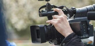 videographer operating a professional camcorder outdoors
