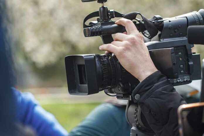 videographer operating a professional camcorder outdoors