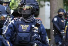 Flawed Data? Judge Stops DHS Home Visits Riot police officer in tactical gear with helmet and visor