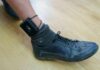 ankle with electronic monitoring bracelet and black shoe