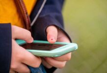 Hands holding a smartphone with a mint-green case