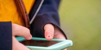 Hands holding a smartphone with a mint-green case