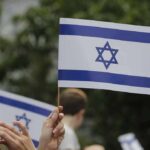 Israeli flag held aloft at an outdoor gathering