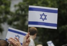 Israeli flag held aloft at an outdoor gathering
