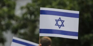 Israeli flag held aloft at an outdoor gathering
