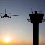 Overtime Crunch Behind Sydney Close Call? Airplane approaching runway near airport control tower at sunset