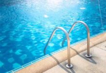 Swimming pool ladder by clear blue water
