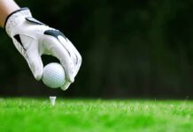 Golf glove placing ball on tee