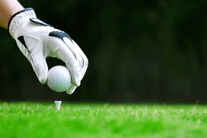 Golf glove placing ball on tee