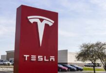 Tesla dealership sign in front of parking lot